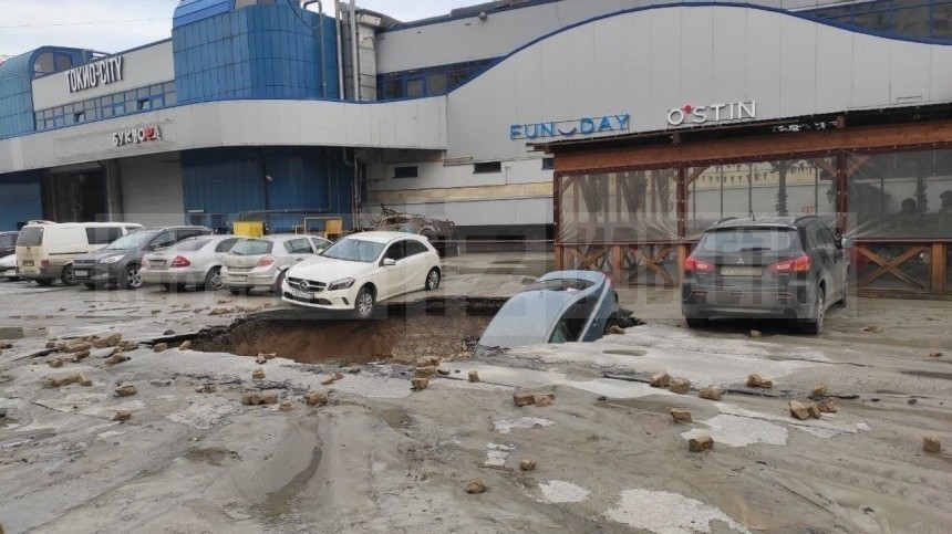 Видео: Машина провалилась под асфальт после прорыва трубы на севере Петербурга